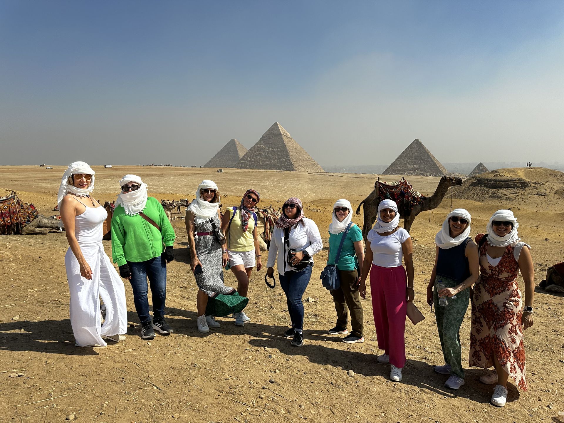 Grupo de viajeras con pañuelos blancos frente a las pirámides de Giza